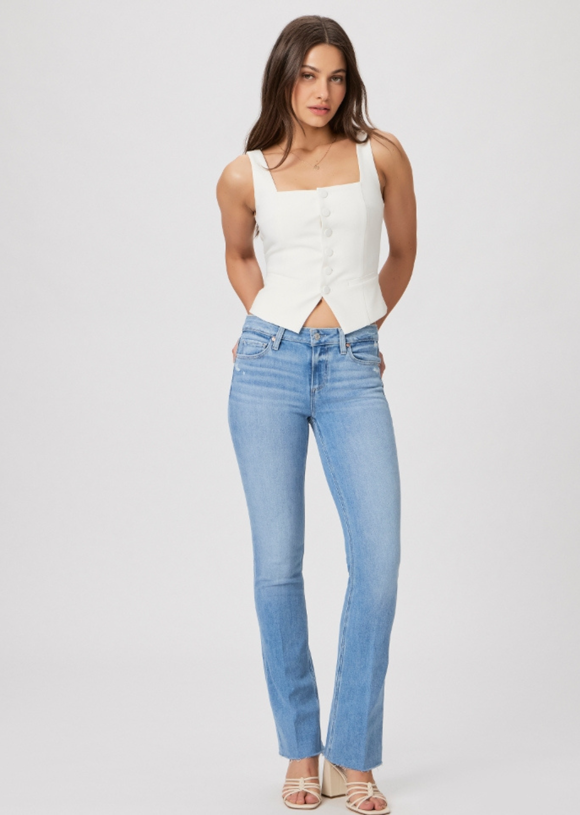 Paige Manhattan Boot 32" - Helena. A universally flattering mid-rise style with a fitted silhouette through the hips and thighs, a slim bootcut from the knee down and a slightly shorter 32” inseam. Cut from our TRANSCEND VINTAGE denim in a bright, powdery blue wash with lived-in details and a raw hem, this style has the look of authentic vintage denim but is incredibly comfortable with plenty of stretch and recovery.