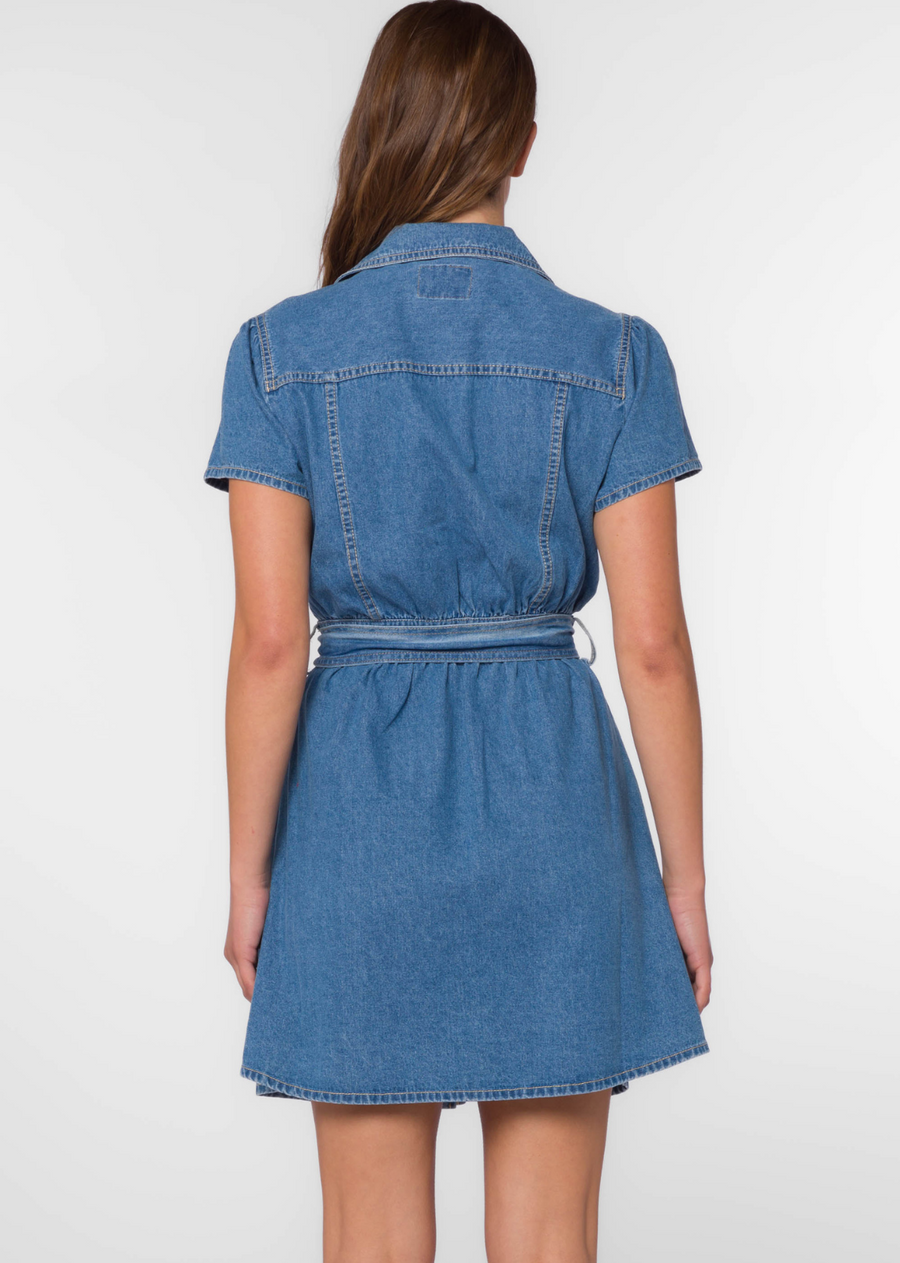 Velvet Heart Fonda- Western Blue. The Fonda Dress in<span> </span><span>Western Blue denim has short cap sleeves and metal snaps button-up with a self belt to cinch the waist for a flattering silhouette. Plenty of pockets and contrasting top-stitching completes the look.