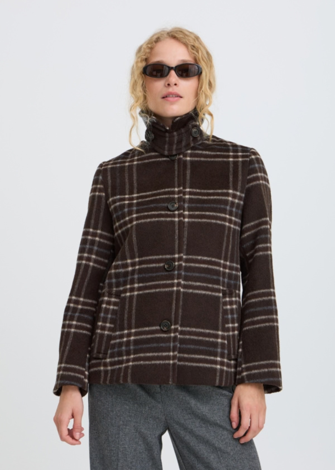Wool look check jacket features a straight, slightly boxy silhouette with a pointed collar and button front. Hip-length design includes long sleeves and side pockets, offering a softly structured shape with a fuzzy texture throughout.