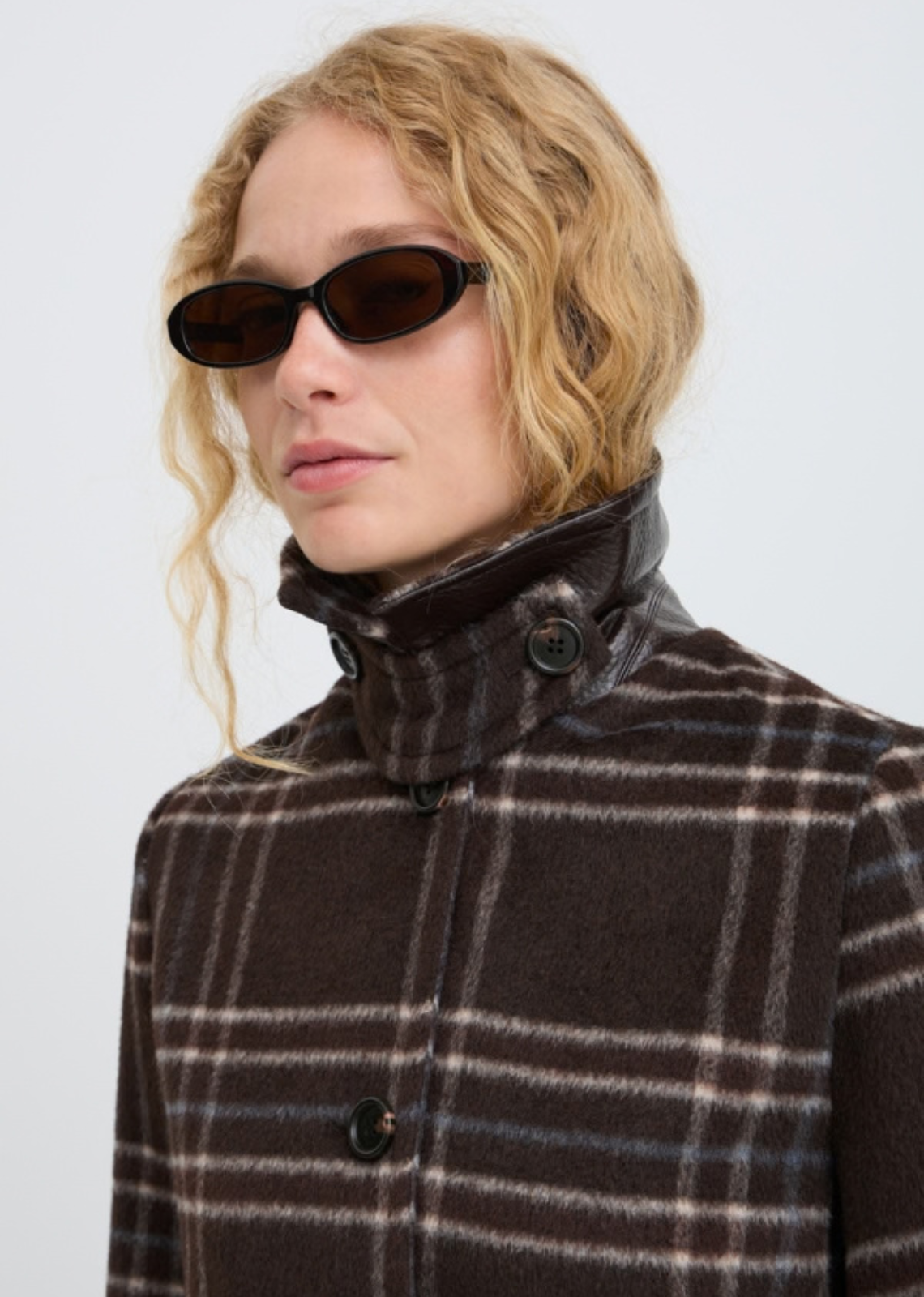 Wool look check jacket features a straight, slightly boxy silhouette with a pointed collar and button front. Hip-length design includes long sleeves and side pockets, offering a softly structured shape with a fuzzy texture throughout.