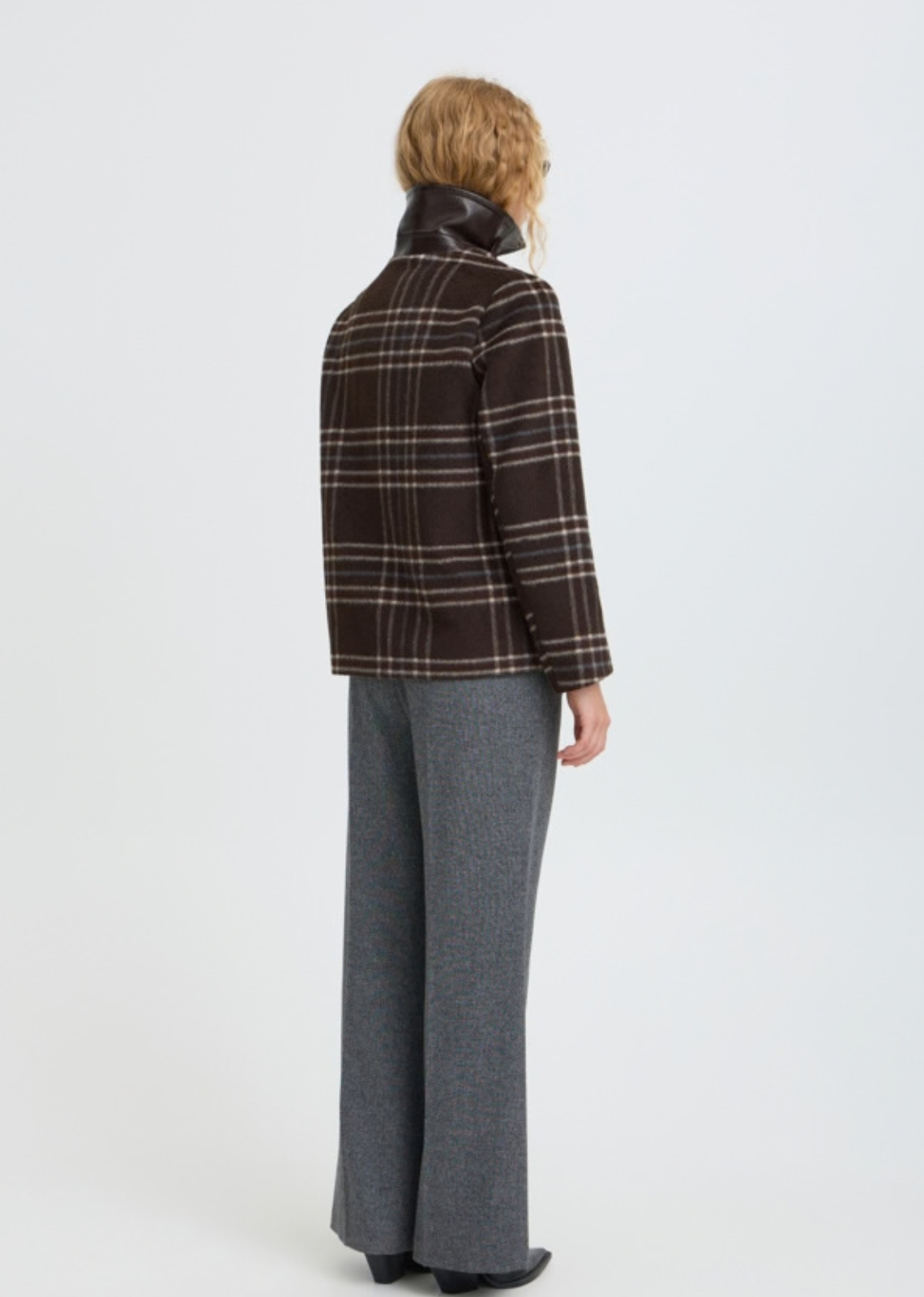 Wool look check jacket features a straight, slightly boxy silhouette with a pointed collar and button front. Hip-length design includes long sleeves and side pockets, offering a softly structured shape with a fuzzy texture throughout.