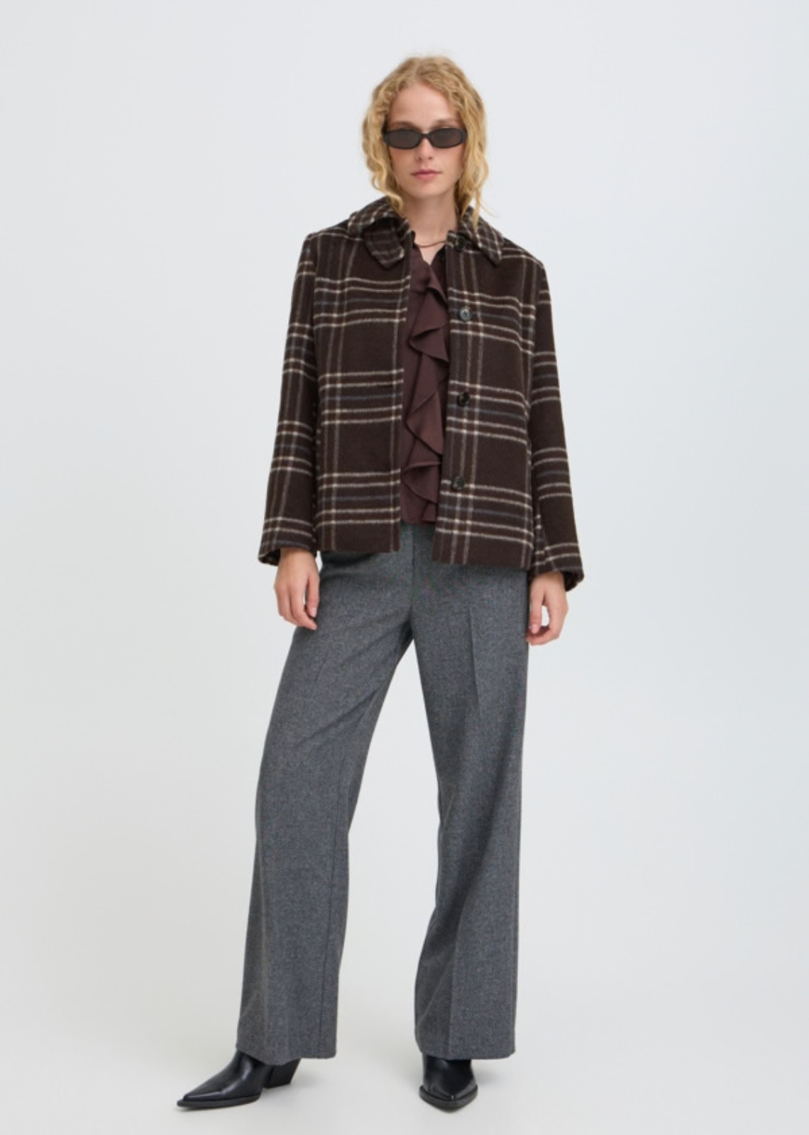 Wool look check jacket features a straight, slightly boxy silhouette with a pointed collar and button front. Hip-length design includes long sleeves and side pockets, offering a softly structured shape with a fuzzy texture throughout.