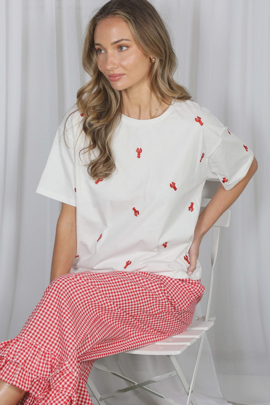 Bring a touch of coastal charm to your everyday wardrobe with The Seabreeze Embroidered Crew Neck Top. Crafted from soft, breathable 100% cotton, this relaxed-fit tee features an adorable red crawfish embroidery for the perfect seaside-inspired look. Designed with a classic crew neckline, drop shoulders, and an easy pullover fit, it's the effortless staple you'll reach for all season long. Pair it with your favorite denim shorts or jeans for beach days, vacations, casual outings, and everything in between.