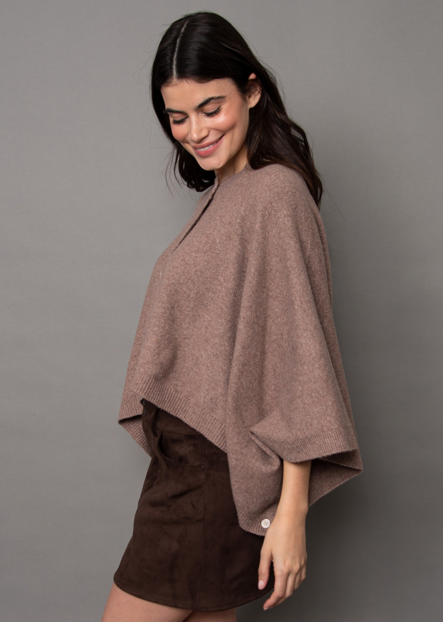 Wrap yourself in effortless chic with this cozy beige/brown striped knit poncho. Designed with a relaxed, draped silhouette and a modern cropped length, this transitional layering piece features a classic crew neckline and a full-length button placket down the front. Finished with refined ribbed trim, it pairs seamlessly with high-waisted denim for a polished, everyday look.