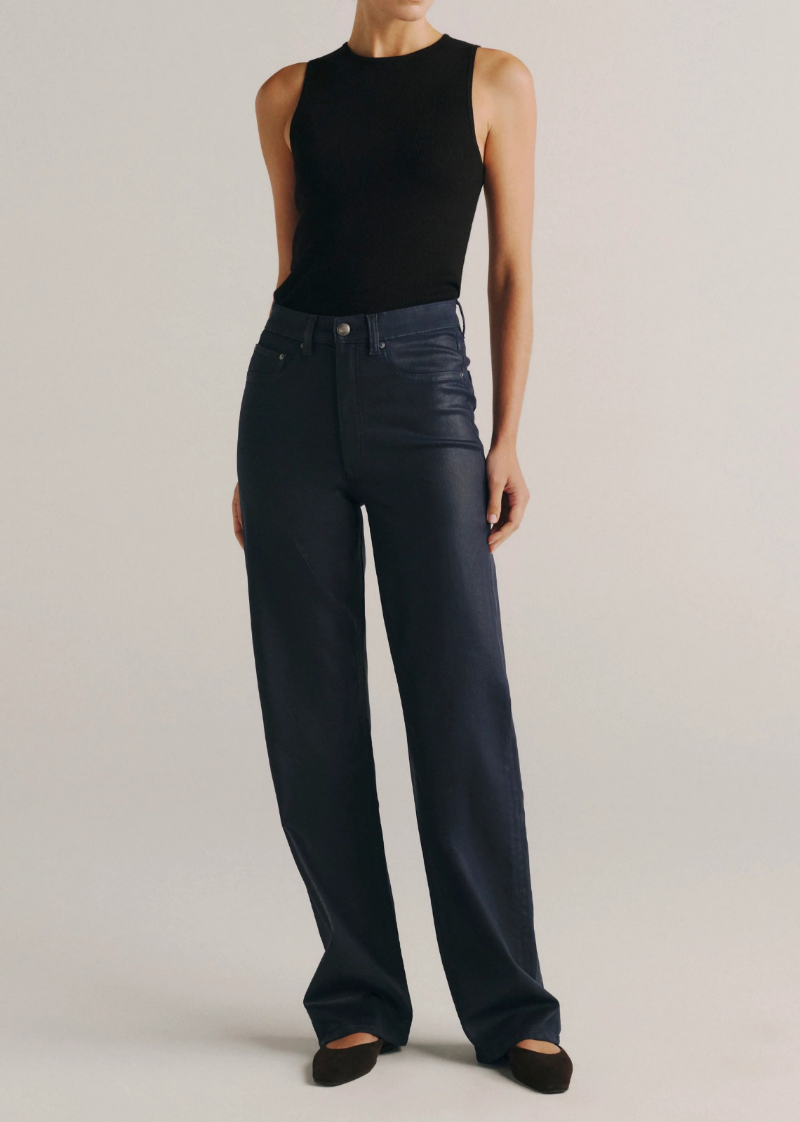 Karmine high-rise wide-leg jeans in deep navy blue coated denim with a leather-like finish, silver hardware, tonal stitching, a clean hem, and a black back patch. Designed with a flattering sculpted fit and a 32-inch inseam.