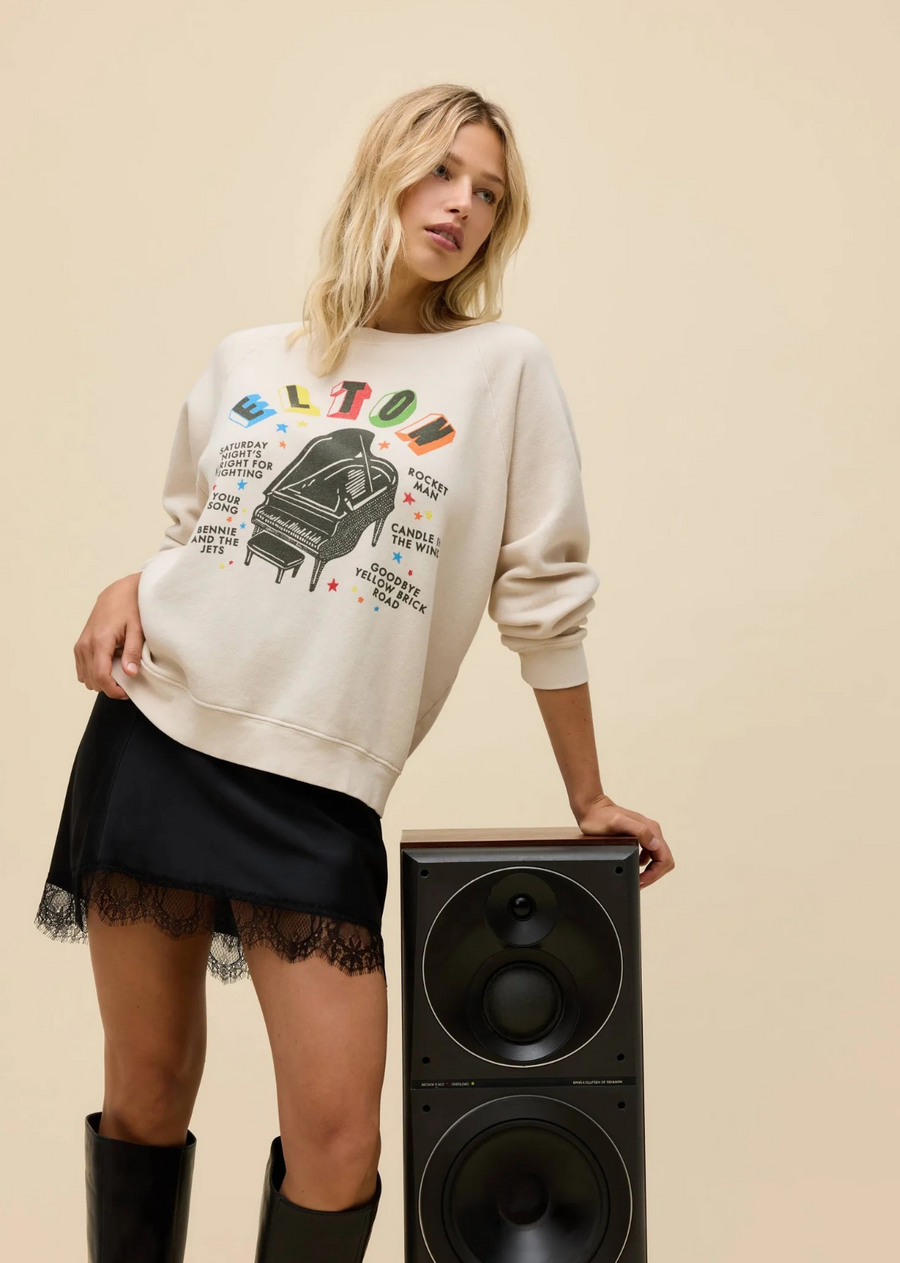 Fit to represent the piano prodigy himself, this multi-colored Elton John Vintage Raglan Sweatshirt highlights the resounding name that's synonymous with stylistic showmanship and a contagious personality. The legend's most iconic, everlasting songs anchor a piano graphic.