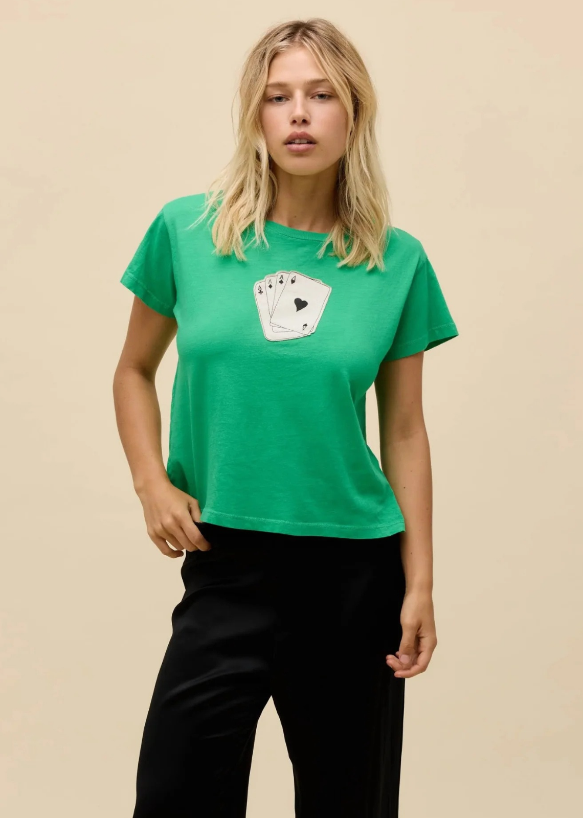 Deal yourself a winning look with this vibrant graphic tee. Crafted in a bold lucky green hue, this classic crewneck features a subtle, vintage-inspired front graphic showcasing a hand of four Ace playing cards. Cut in a relaxed yet classic fit, it’s designed to bring a touch of playful charm to your everyday wardrobe. Pair it with tailored black trousers for a sleek high-low contrast or throw it on with your favorite vintage denim for an effortless weekend vibe.