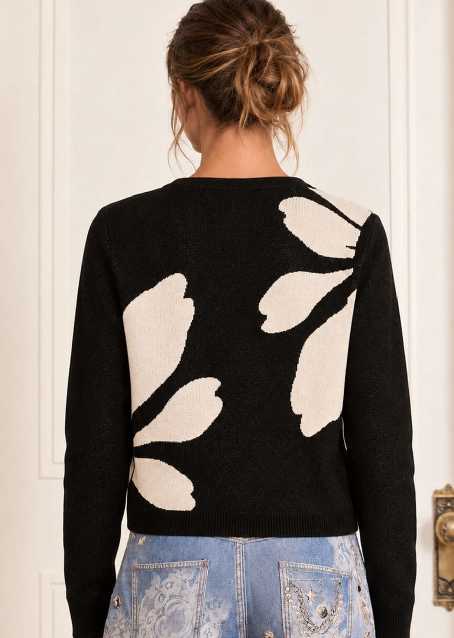 Elevate your knitwear rotation with this striking black and cream cardigan. Featuring a bold, artistic intarsia floral pattern across the front, this classic crewneck style combines timeless tailoring with modern graphic appeal. Finished with a front button placket and ribbed trim, it’s a chic layering piece that effortlessly dresses up casual denim or pairs back to tailored trousers and skirts. Pair the matching caridgan with the Elin Dress.