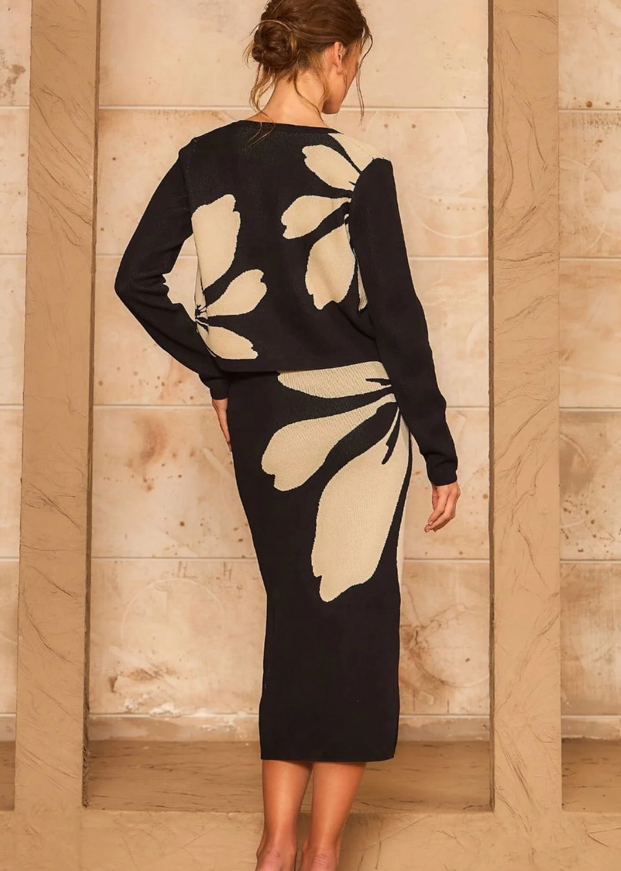 Make a bold statement with this sophisticated black and cream knit set. Featuring a cohesive, large-scale abstract floral motif that spans across both pieces, this matching set combines a classic long-sleeve button-down cardigan with a sleek, form-fitting midi skirt. Crafted from a soft, cozy knit fabric, it delivers high-impact style with maximum comfort—perfect for transitioning through the seasons.