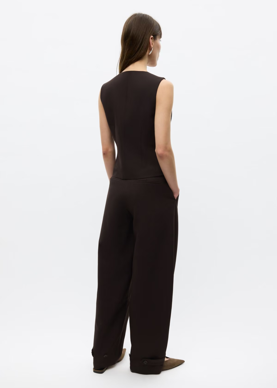 Sleeveless vest with a slim fit. Asymmetric button closure on the front. V-neck. Two welt pockets on the front. Fully lined. Main material made from a recycled polyester blend.