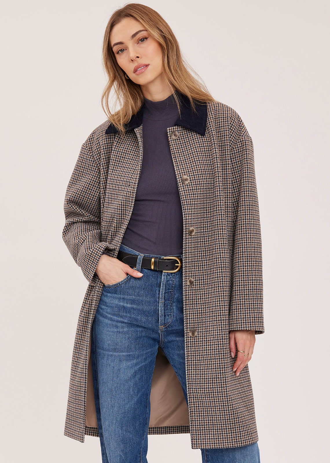 The Millie coat is made of a brushed herringbone fabric and is fully lined. Features include a contrast corduroy collar, welt pockets, and a back vent.