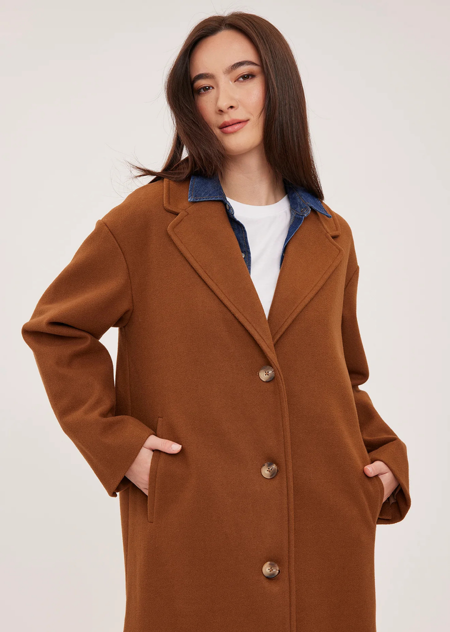The Agatha coat is made of a soft, brushed melton fabric and is fully lined. Features include a front button closure, welt pockets, and side slits.