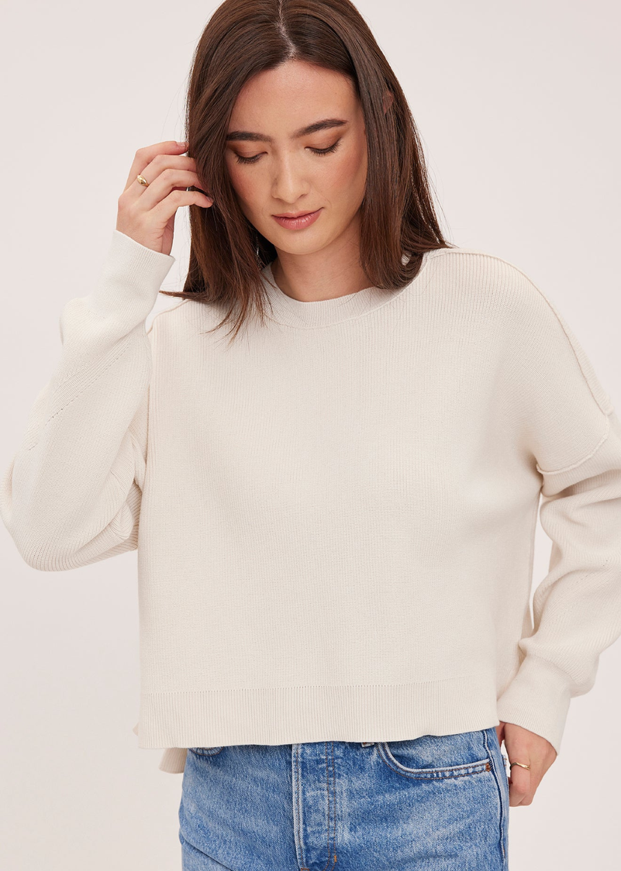 The Echo sweater is made of a super soft yarn in a half cardigan stitch. Features include exposed seam detailing and side slits for an effortless look.