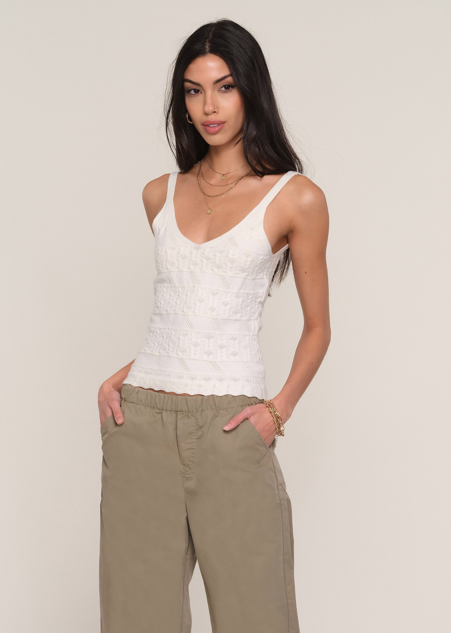 Elevate your everyday wardrobe with this effortlessly feminine knit cami. Designed with a flattering V-neckline and wide shoulder straps, this sleeveless style features an intricate pointelle knit pattern that adds beautiful texture and subtle dimension. The fitted silhouette hugs comfortably while the soft knit fabric offers all-day wearability. Finished with a delicate scalloped hem, it's the perfect piece to wear on its own or layered beneath a lightweight cardigan or blazer.