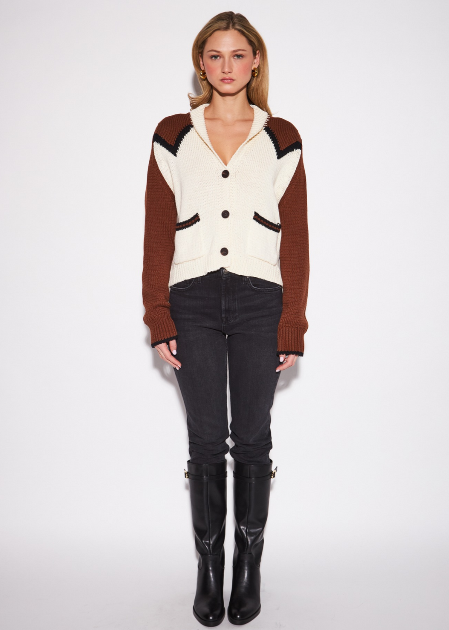 The Collins Cardigan by John &amp; Jenn blends vintage-inspired charm with effortless everyday style. Designed in a creamy ivory with warm brown sleeves, it features bold black geometric chevron trim and front patch pockets for a distinctive finish. The V-neckline, soft collar, and three-button closure create a polished yet relaxed silhouette, while ribbed edges add subtle structure.&nbsp;Made from 100% cotton, it’s an easy layering piece that brings a touch of Western character to any outfit.