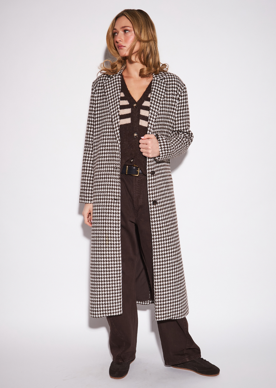 The Sofia is an elegant open-front layer designed to create a long, fluid column through the body. Its elongated silhouette is&nbsp;paired with a sophisticated houndstooth pattern, bringing classic structure and visual depth to the look. Wear it over a fine knit&nbsp;with tailored trousers for a polished layered outfit, or soften the tailoring with denim and boots. A statement layering piece that&nbsp;feels equally refined and effortless.