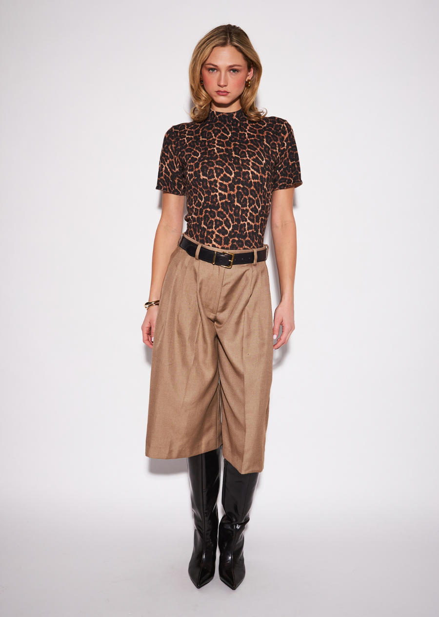 The Vivienne makes leopard print feel sleek and sophisticated through a clean, fitted short-sleeve silhouette. The streamlined
shape allows the statement pattern to take center stage without overwhelming the look, making it surprisingly versatile from day
through evening. Tuck it into tailored trousers for a polished outfit, or style it with a midi skirt and understated accessories for an
elevated evening look.