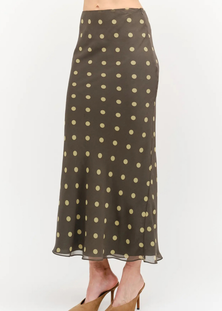 Add a touch of retro charm to your wardrobe with this chic polka dot midi skirt. Cut on the bias to beautifully skim the contours of the body, this piece features a flattering high-rise waist and a fluid, gentle flare at the hem for effortless movement. The timeless pattern set against a rich, earthy background makes it an incredibly versatile piece to dress up or down.