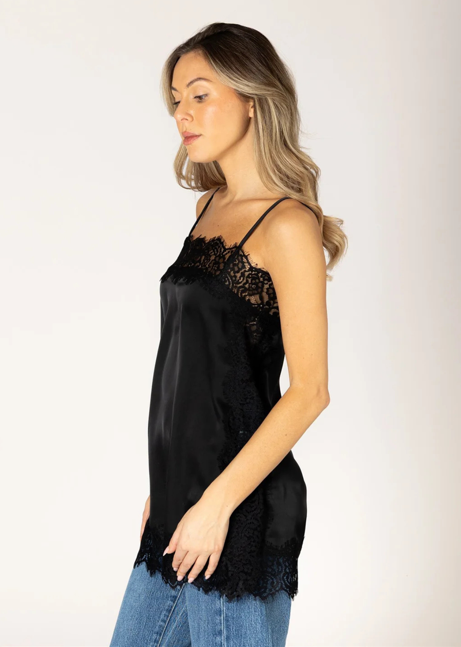 Elevate your everyday wardrobe with this effortlessly feminine satin cami. Designed with a relaxed, flowy silhouette, it features delicate lace trim along the neckline, hem, and sides for a romantic touch. Adjustable spaghetti straps provide the perfect fit, while the silky fabric drapes beautifully for an elegant look.&nbsp; This is the perfect layering piece to add to your collection, pair in under your sweater or wear a short/long sleeve under. Looks great with denim or a tailored trouser, perfect for bo