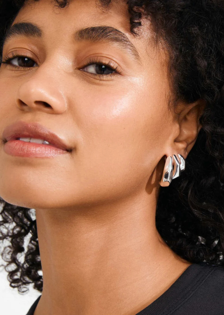 Feel your PRESENCE rise! The silver-plated PRESENCE earrings from Pilgrim serve up a bold, urban statement with their edgy, high-shine surfaces. Their sculptural shapes create the illusion of multiple chunky hoops in one piece, adding a powerful, high-fashion coolness to any look. Crafted from durable and waterproof materials made with 99% recycled content—because it’s the little details that make all the difference.
