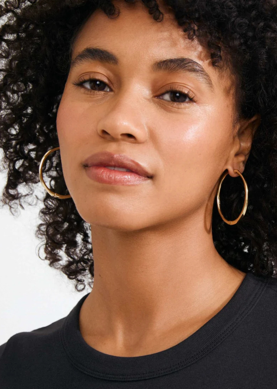 Stay in your PRESENCE! The gold-plated PRESENCE hoops from Pilgrim are all about that high-shine finish and sleek, organic silhouette. Soft, subtly faceted surfaces catch the light just right, making these earrings perfect for everything from everyday looks to those dressed-up moments. Easy click clasps mean you can pop them on in seconds—no fuss. Crafted from 99% recycled materials, they prove that the little details really do make a difference.