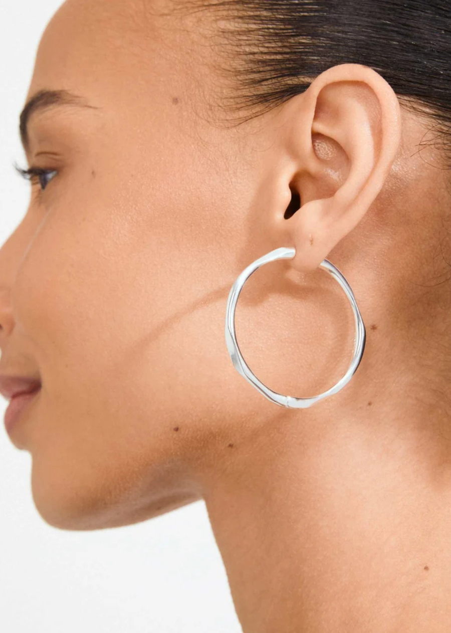Stay in your PRESENCE! The silver-plated PRESENCE hoops from Pilgrim are all about that high-shine finish and sleek, organic silhouette. Soft, lightly faceted surfaces catch the light just right, making these earrings perfect for everything from everyday looks to those dressed-up moments. Easy click clasps mean they’re a breeze to wear. Crafted from durable, water-resistant materials and made with 99% recycled content—because it’s the little details that make all the difference.