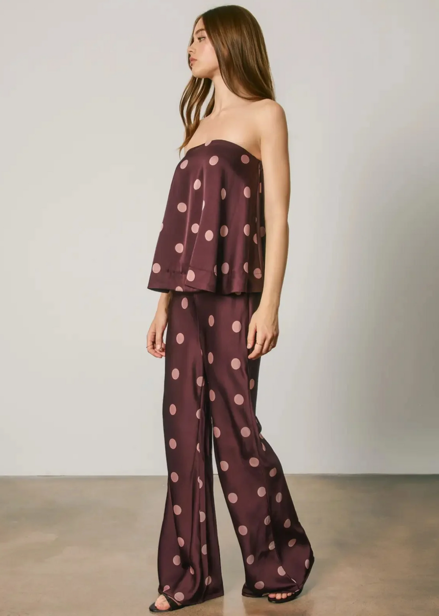 Statement sleek satin pants featuring a polka dot print. Designed with a high-rise fit and fluid silhouette for an effortlessly elevated look, perfect for pairing with the matching top, heels, or sleek evening separates. Models are 5'9" and wearing size Small.