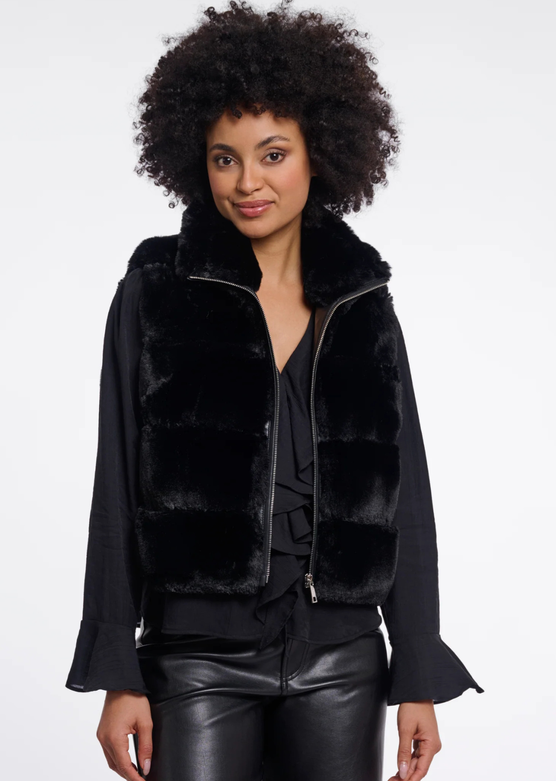 A faux fur waistcoat with a relaxed sleeveless silhouette, designed for effortless layered styling. The tactile finish adds depth to everyday looks, while the clean shape makes it easy to wear over knitwear, blouses or long-sleeve tops through the season.