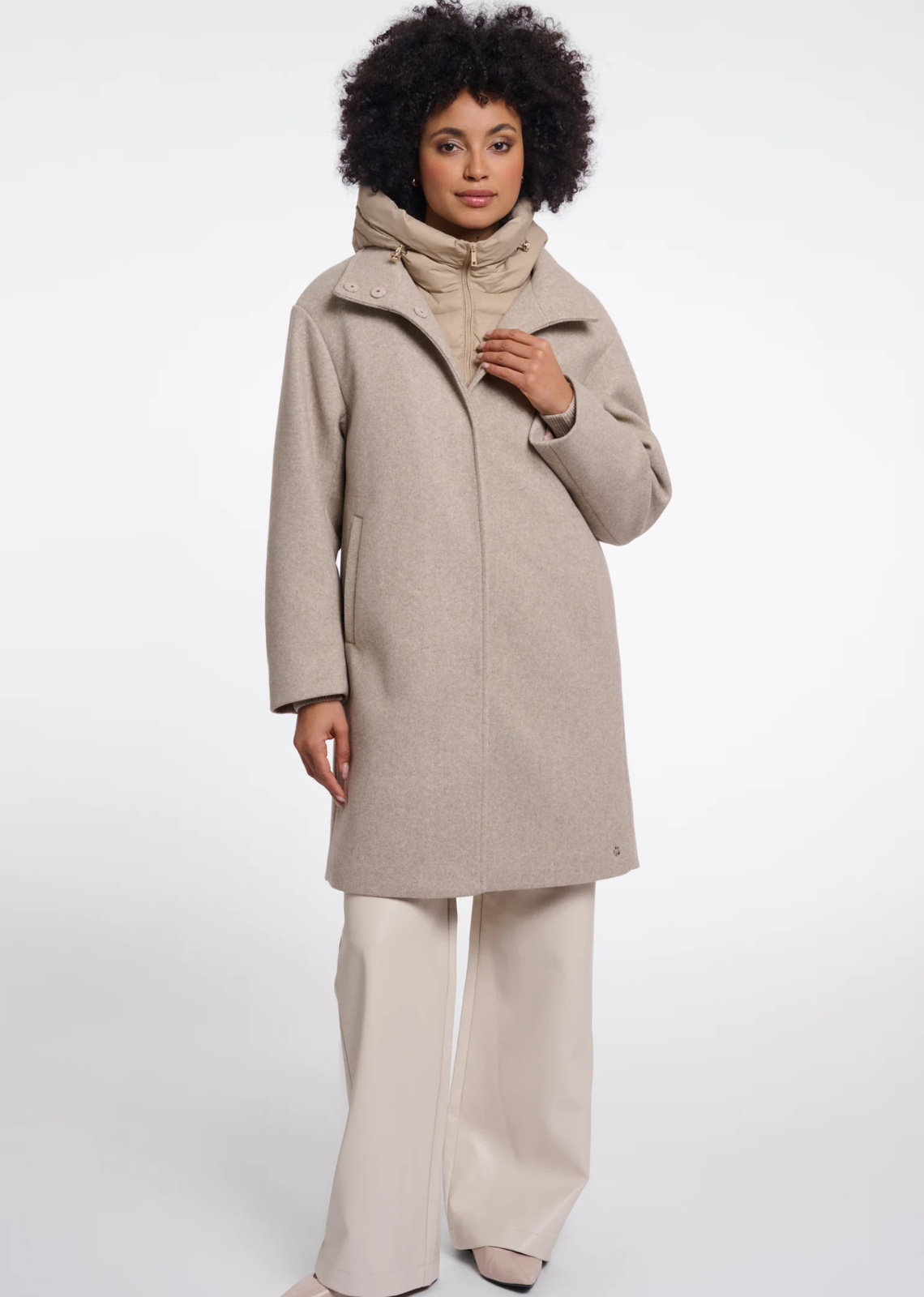 A coat with a detachable insert bodywarmer, designed for versatile layered styling. The bodywarmer can be worn separately or secured inside the coat with discreet loops and buttons, keeping it neatly in place when layered. A practical yet polished outerwear piece for changing seasonal needs.