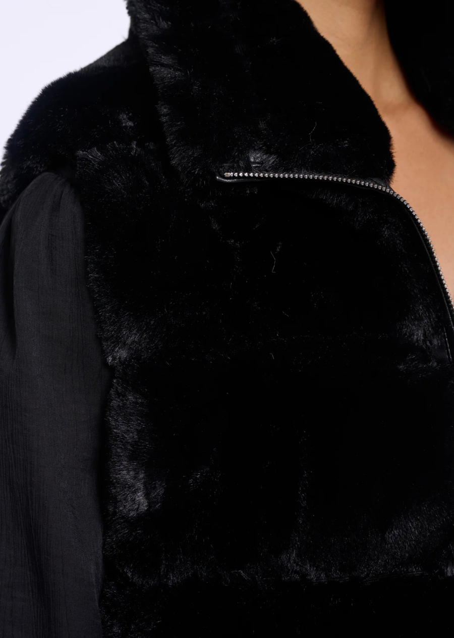 A faux fur waistcoat with a relaxed sleeveless silhouette, designed for effortless layered styling. The tactile finish adds depth to everyday looks, while the clean shape makes it easy to wear over knitwear, blouses or long-sleeve tops through the season.