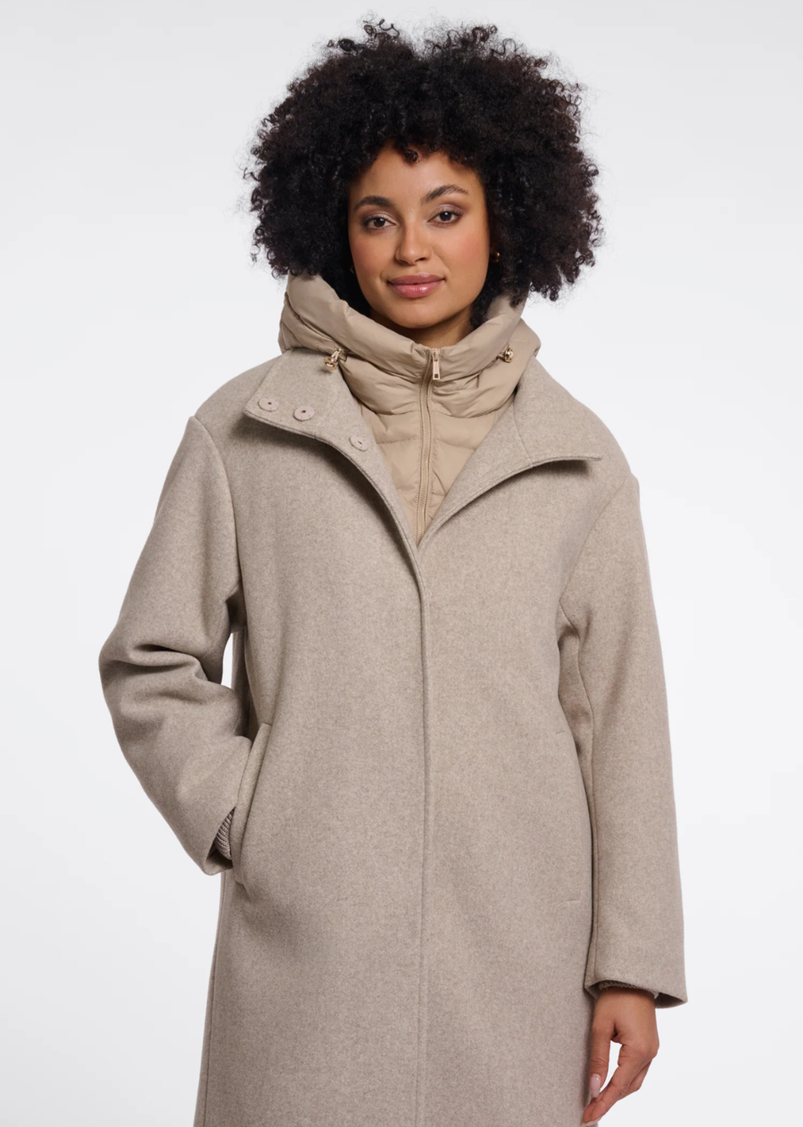 A coat with a detachable insert bodywarmer, designed for versatile layered styling. The bodywarmer can be worn separately or secured inside the coat with discreet loops and buttons, keeping it neatly in place when layered. A practical yet polished outerwear piece for changing seasonal needs.