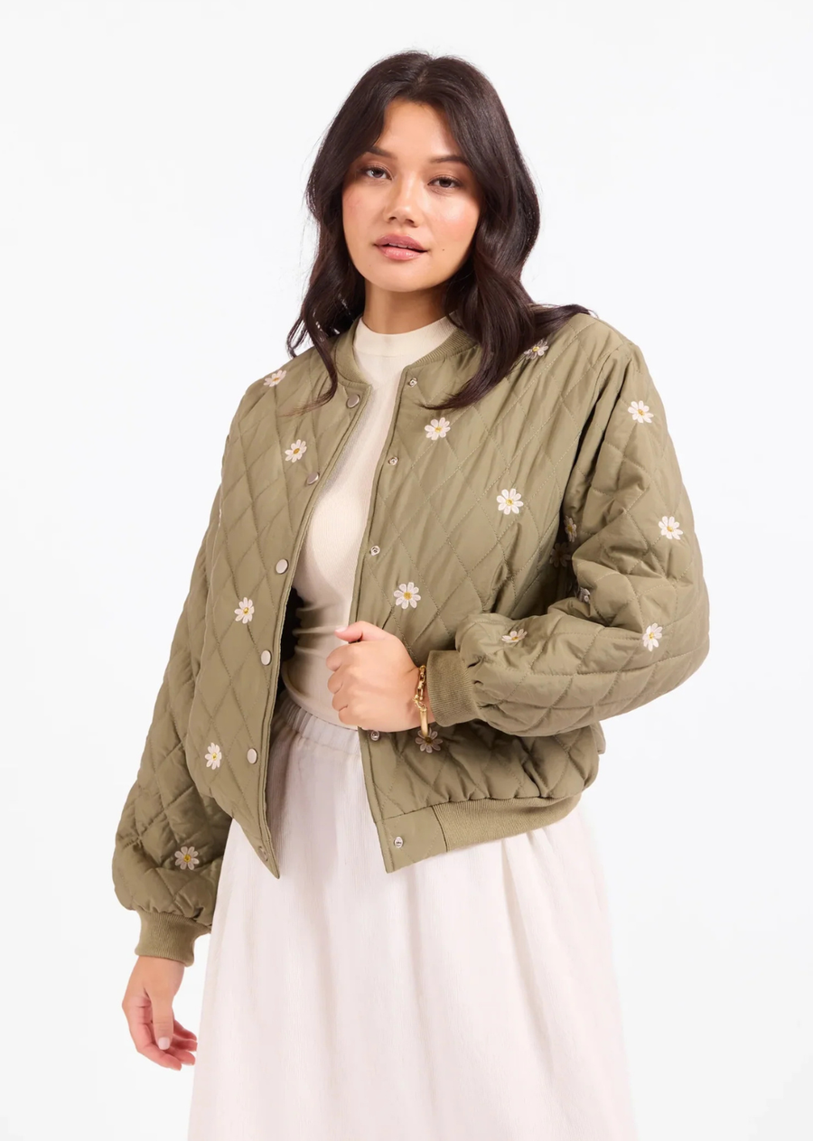 Effortlessly blending utilitarian utility with charming cottagecore whimsy, this bomber-style quilted jacket adds a cozy, playful layer to any transitional outfit.