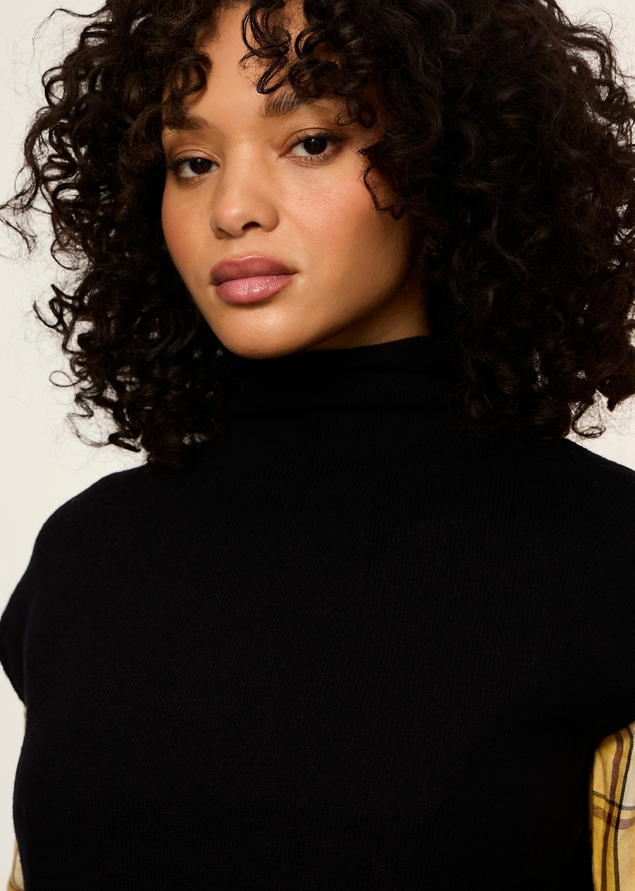 This timeless black sweater vest (or sleeveless mock-neck shell) offers a versatile, modern essential designed for effortless layering. It blends minimalist sophistication with a preppy, autumn-ready feel, making it a functional wardrobe hero across seasons.