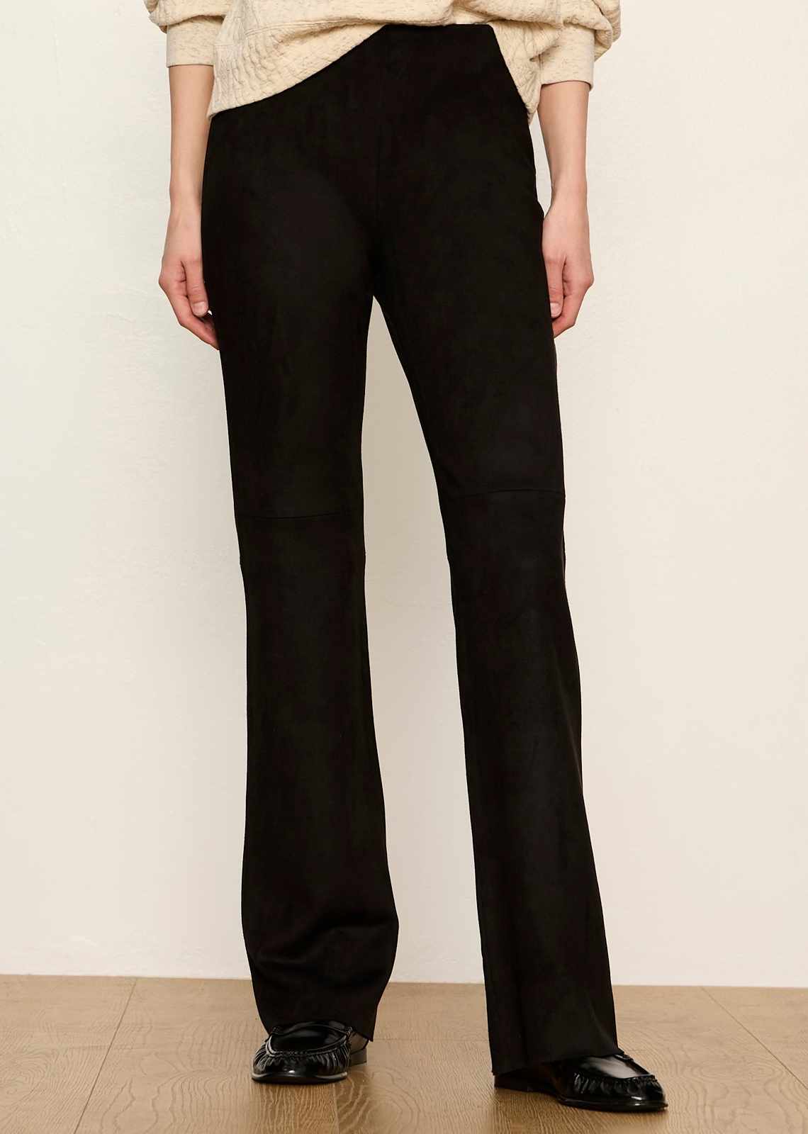 These elevated black leggings combine the plush, velvety texture of suede with the clean structure of tailored pants. Designed with a pull-on fit that contours through the hips and thighs before releasing into a subtle kick-flare, they offer a sophisticated, cozy-chic option for cool-weather dressing.