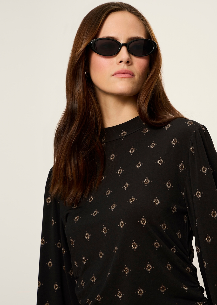 This long-sleeve blouse combines a bohemian print with modern tailored details for an effortless day-to-night look. Rendered in a dark neutral base with subtle metallic or warm-toned geometric accents, it offers a sophisticated yet relaxed vibe