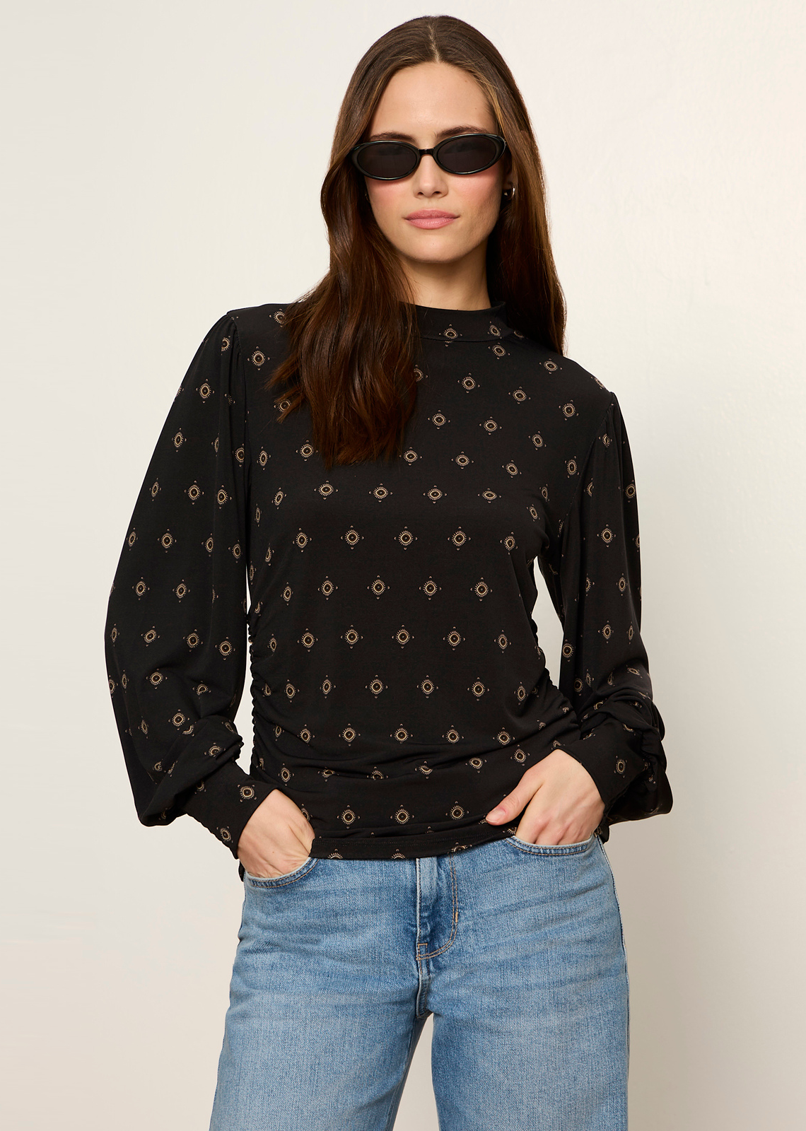 This long-sleeve blouse combines a bohemian print with modern tailored details for an effortless day-to-night look. Rendered in a dark neutral base with subtle metallic or warm-toned geometric accents, it offers a sophisticated yet relaxed vibe