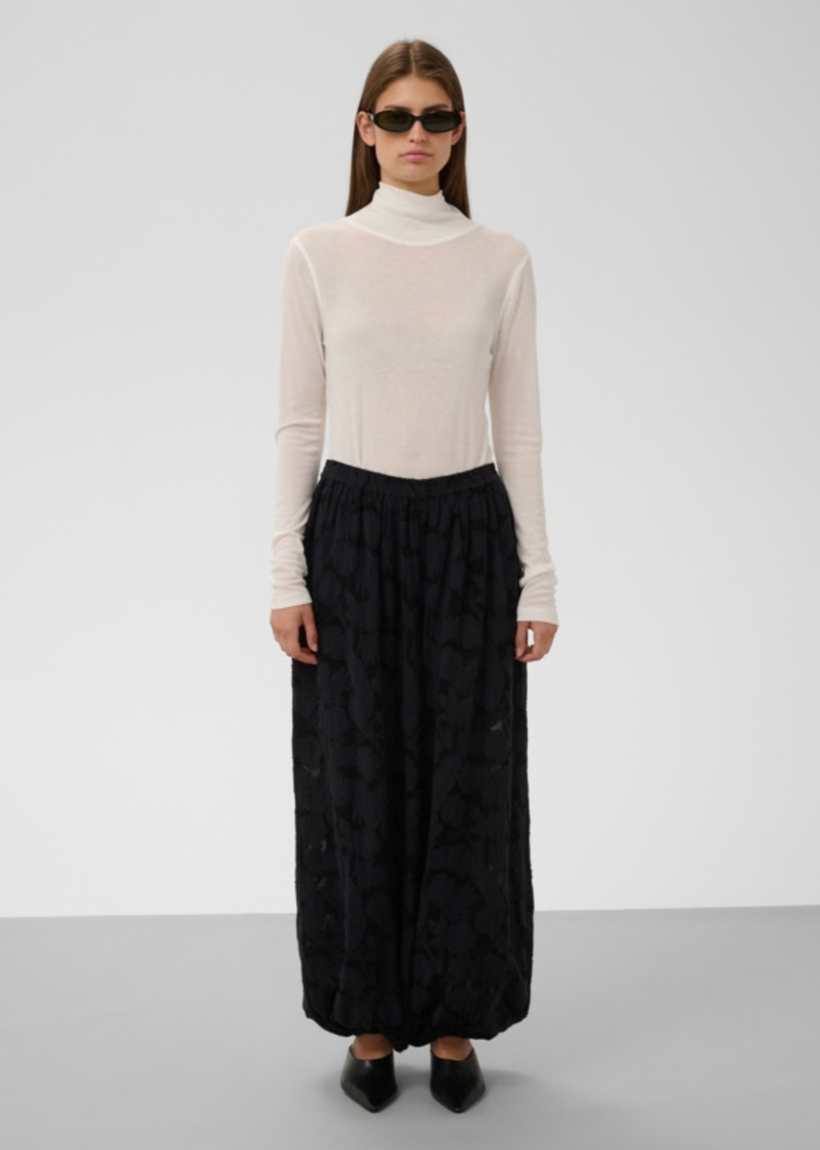 Make an artistic statement with these airy, dramatic balloon pants crafted in a tonal black floral jacquard pattern. Designed with lightweight fluid movement, delicate burnout-style floral textures, and a volumetric balloon silhouette, this pair offers equal parts relaxed comfort and high-fashion allure.