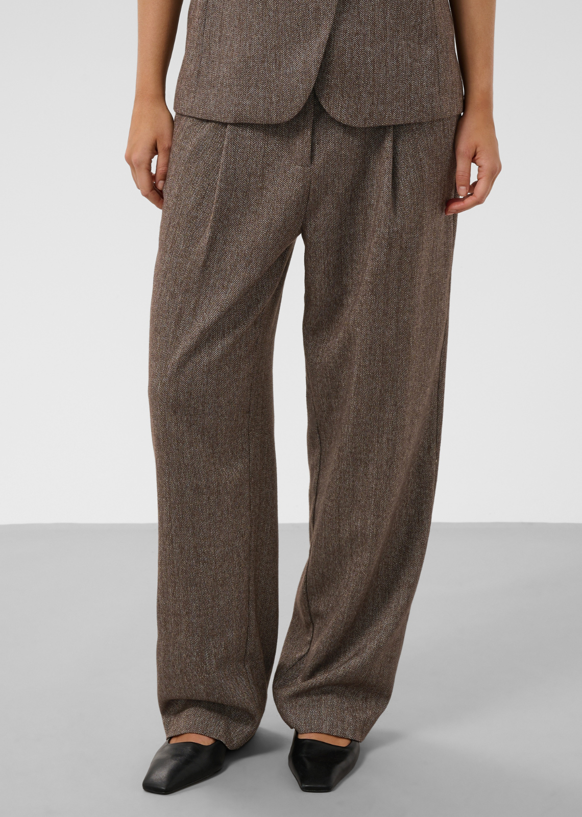 Bring refined tailoring to your wardrobe with these relaxed wide-leg trousers in a classic&nbsp;heathered brown herringbone knit. Blending structural precision with comfortable fluid drape, they offer a sophisticated foundation for effortless suiting and separates.
