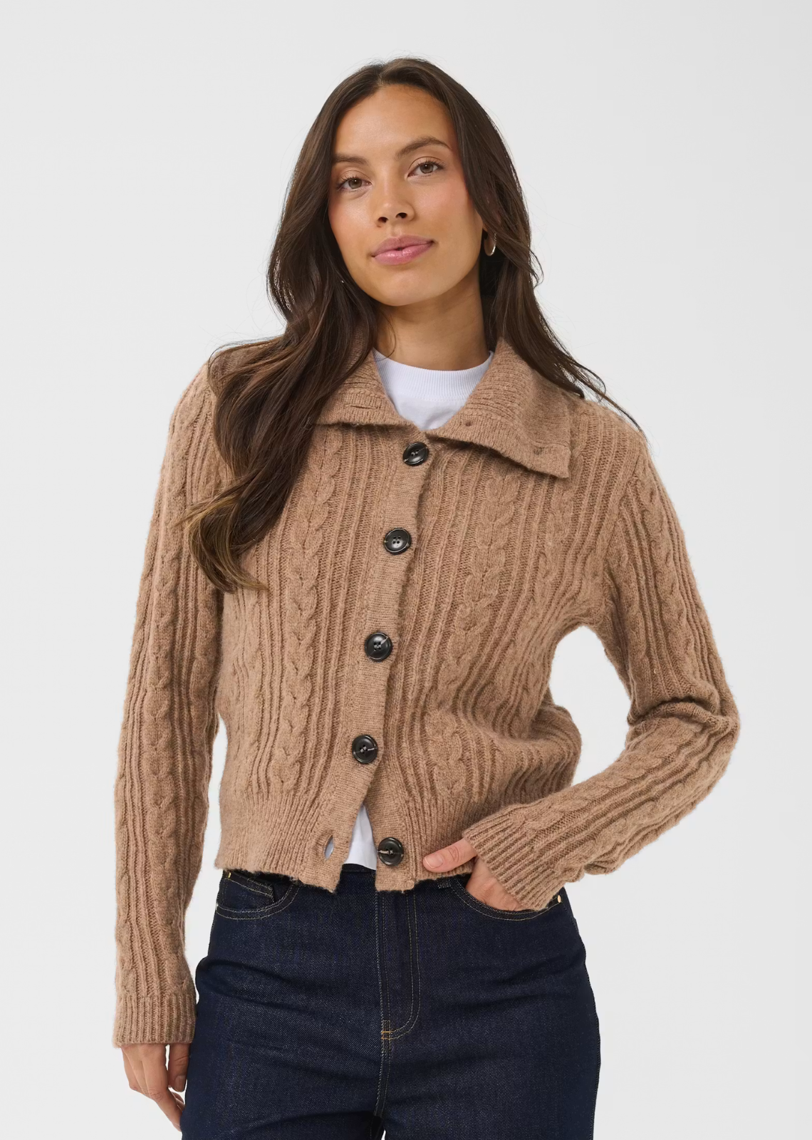 This cable knit cardigan features a straight fit with a hip-length cut and a prominent wide collar. It has long sleeves, ribbed cuffs and hem, and a front button closure with large buttons.