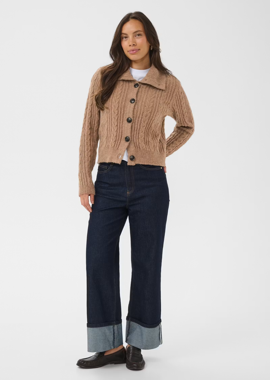 This cable knit cardigan features a straight fit with a hip-length cut and a prominent wide collar. It has long sleeves, ribbed cuffs and hem, and a front button closure with large buttons.