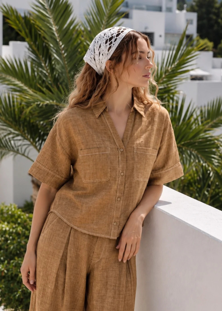 The Marina Linen Camp Shirt - Brown is the perfect warm-weather staple. Crafted from a breathable linen-cotton blend, this lightweight button-up features a relaxed boxy silhouette, classic camp collar, and oversized patch pockets for an elevated yet casual look. Contrast stitching adds a modern touch, while the textured fabric creates an easy, laid-back style perfect for vacations, beach days, and everyday wear.