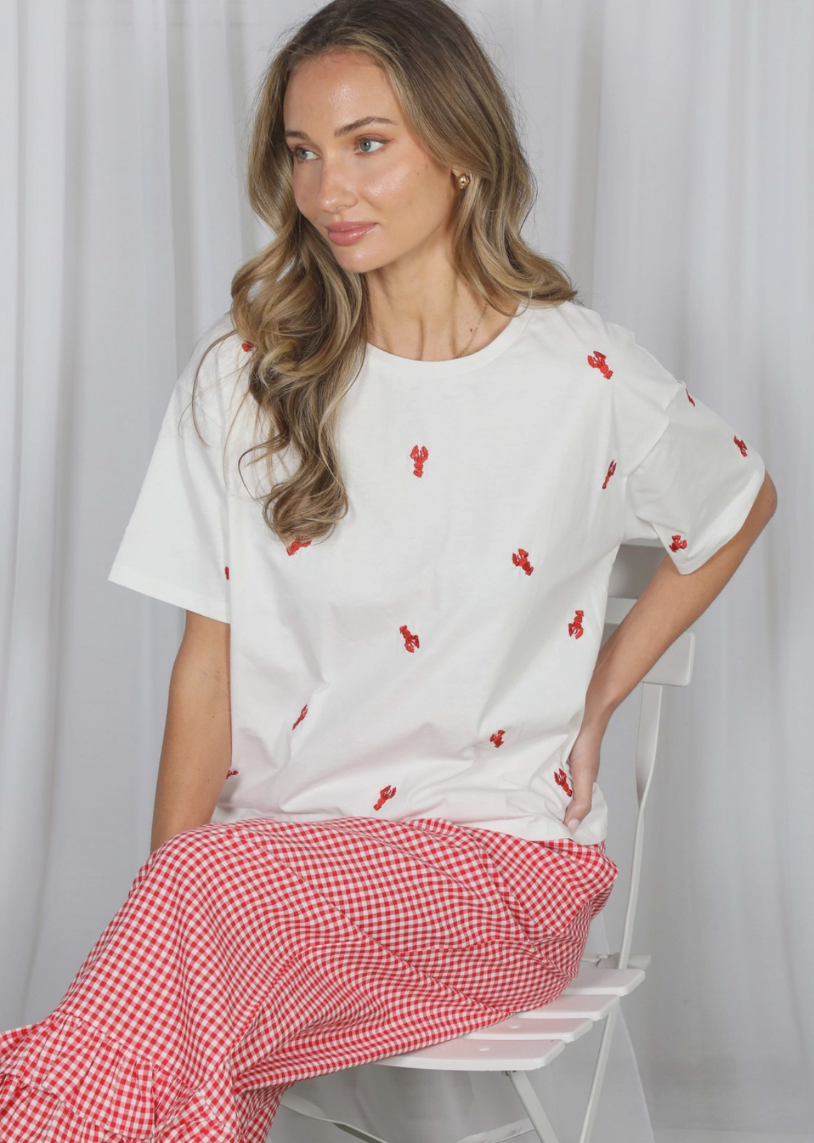 Bring a touch of coastal charm to your everyday wardrobe with The Seabreeze Embroidered Crew Neck Top. Crafted from soft, breathable 100% cotton, this relaxed-fit tee features an adorable red crawfish embroidery for the perfect seaside-inspired look. Designed with a classic crew neckline, drop shoulders, and an easy pullover fit, it's the effortless staple you'll reach for all season long. Pair it with your favorite denim shorts or jeans for beach days, vacations, casual outings, and everything in between.