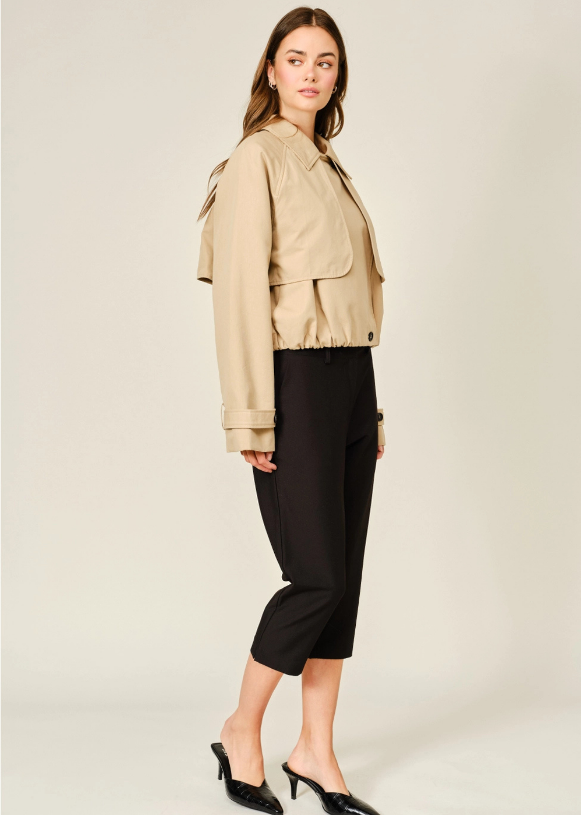 Modern half trench coat featuring a convertible collar, layered front flap, structured silhouette, and elasticized hem.