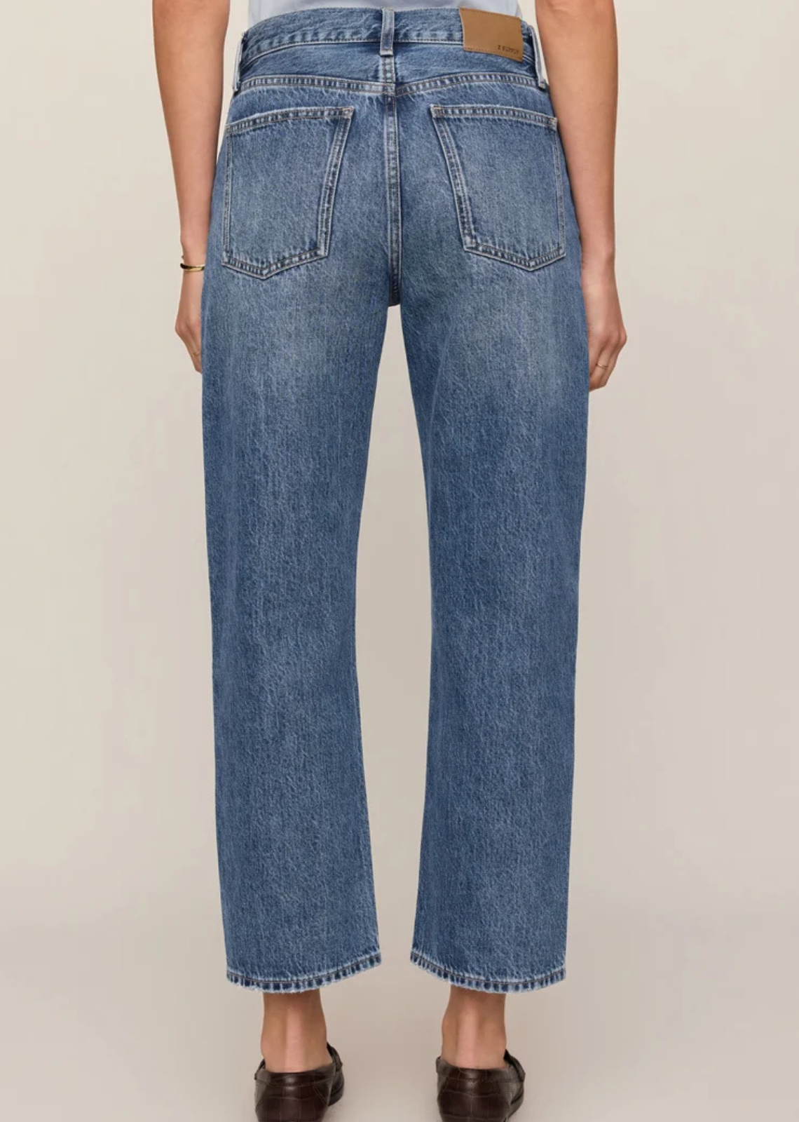  Vintage-wash mid-rise jeans featuring a relaxed bowed-leg silhouette, ankle-length hem, and classic five-pocket design in 100% cotton denim.



