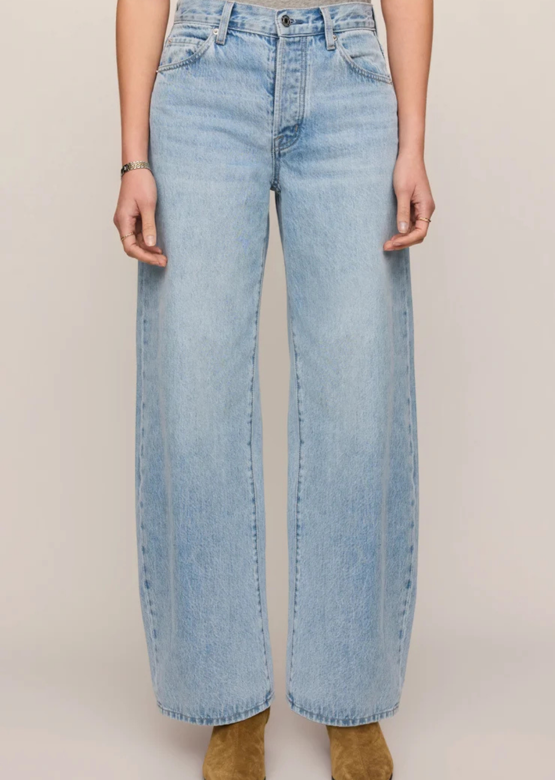 Light vintage-wash, high-rise bowed-leg jeans in rigid 100% cotton denim, styled with a fitted top.