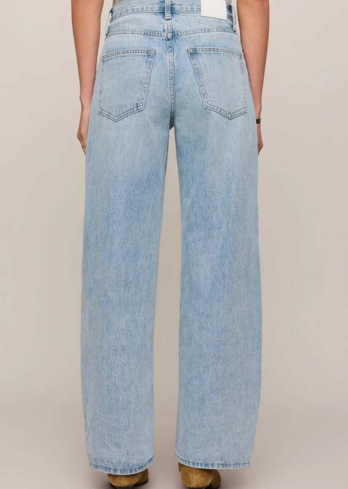 Light vintage-wash, high-rise bowed-leg jeans in rigid 100% cotton denim, styled with a fitted top.
