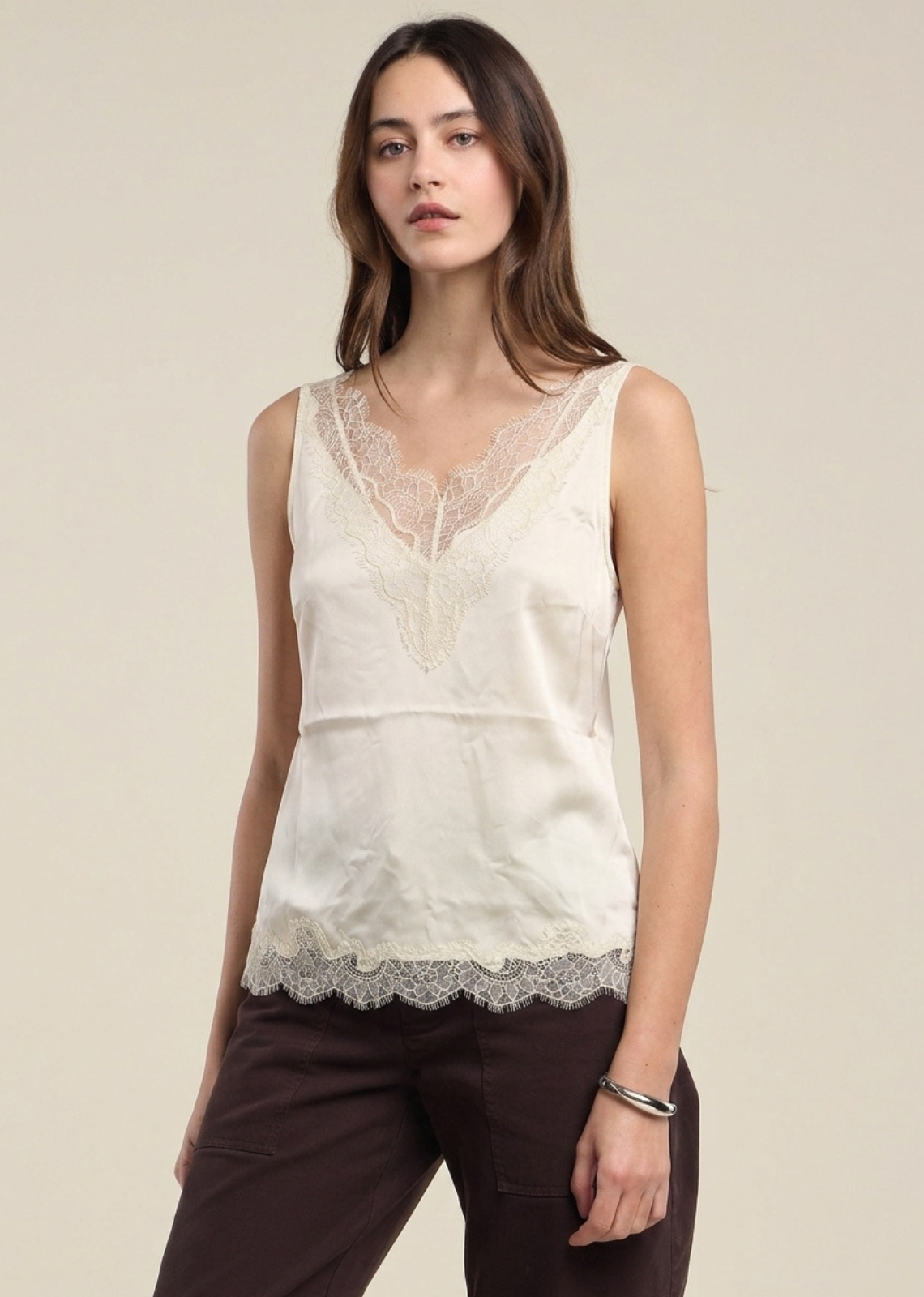This sleeveless black camisole offers a sultry, sophisticated aesthetic crafted from a smooth, lustrous silk fabric.