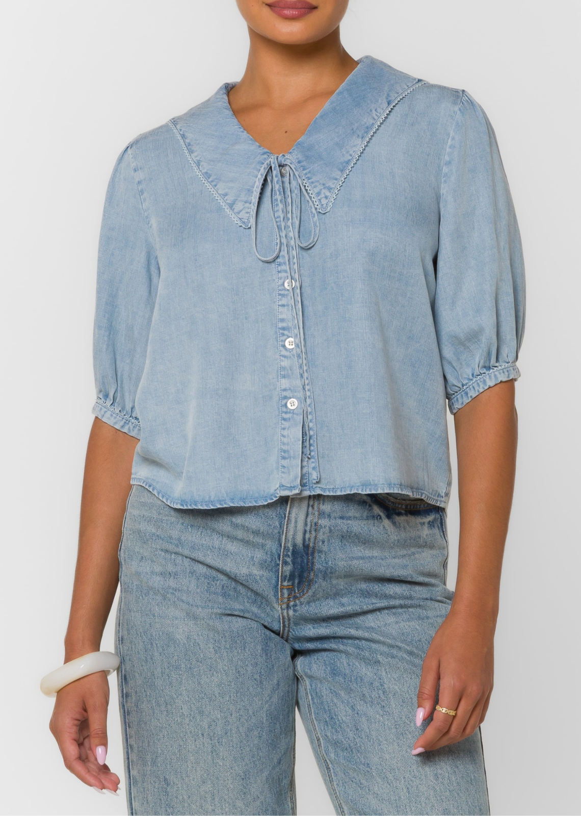 This drapey denim-look blouse features puff sleeves, a feminine tie neckline, Peter Pan collar for a lightweight feel and effortless movement.