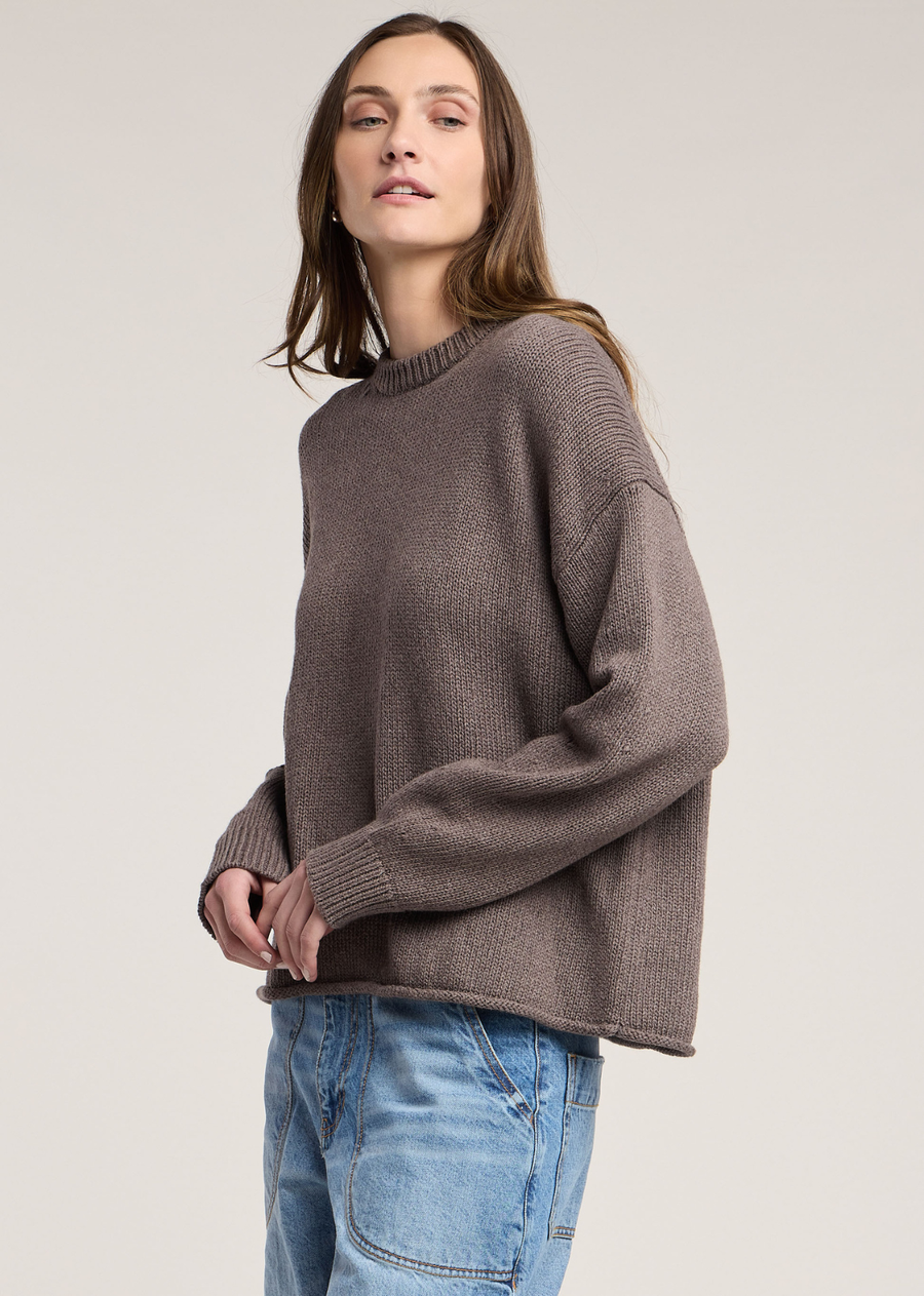 Rendered in a rich cocoa brown hue, this cozy long-sleeve sweater offers an effortless blend of comfort and style in a soft cotton-cashmere knit. Designed with a relaxed, boxy fit, it features dropped shoulders that drape loosely into long sleeves with fine ribbed cuffs. A classic ribbed crew neckline frames the piece, while a subtly rolled trim along the straight hemline adds a touch of casual texture.