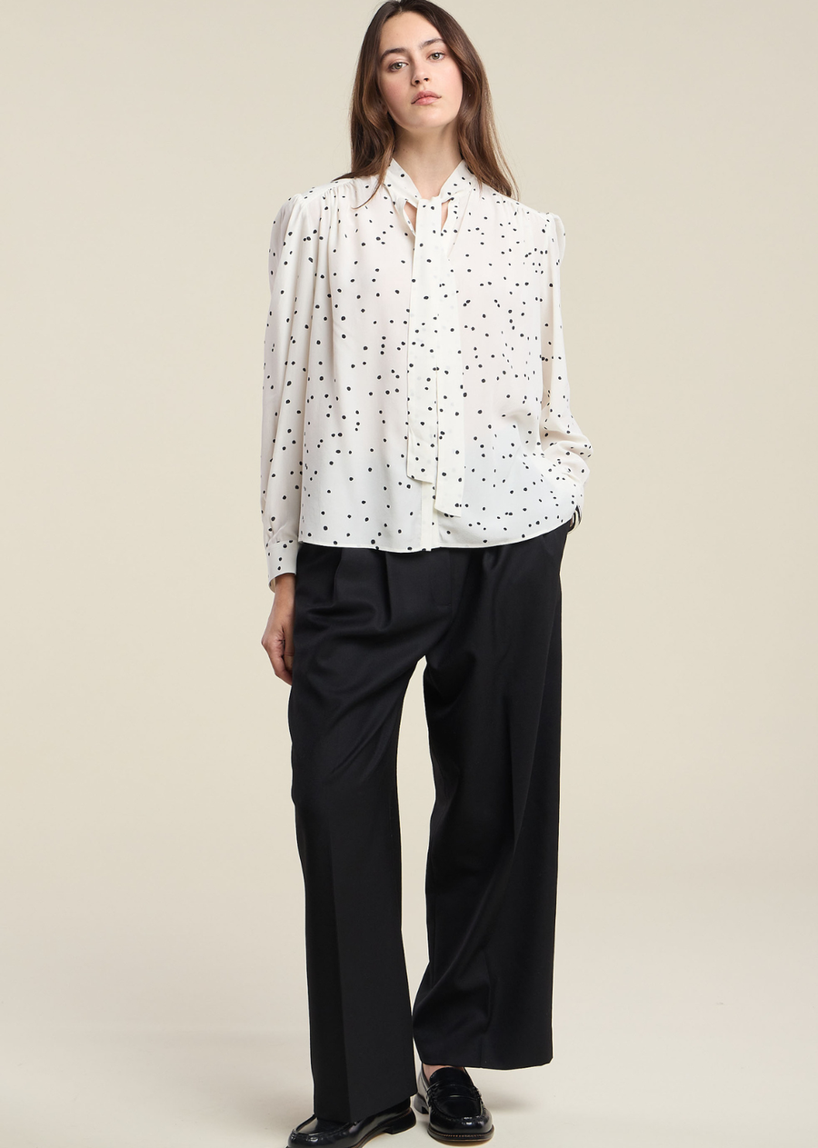 Timeless and polished, the Alma is a polka dot printed blouse crafted from 100% silk. It features a tie-neck design, a self-covered button front, and long sleeves with self-covered button cuffs for a refined, seamless finish. The silk fabric drapes with a fluid, luxurious movement that elevates any look. Wear it tucked into tailored trousers for the office, or with denim for a dressed-up weekend look.